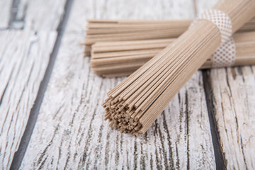 Dried raw soba noodle stick over wooden background
