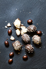 Chocolate candies with stuffing on a dark stone background, sele
