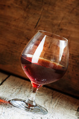 Cognac in a glass on the old wooden background, selective focus