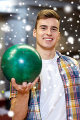 Fototapeta premium happy young man holding ball in bowling club