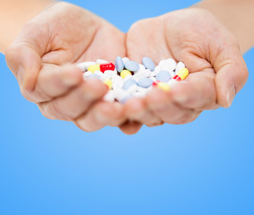 close up of senior woman hands with pills