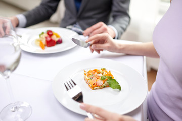 close up of couple eating appetizers at restaurant