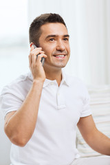 happy man calling on smartphone at home