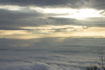 Golden light of the sun in the valley filled with fog