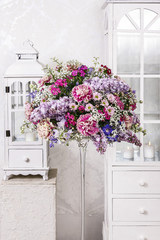 Bouquet of carnations, lilacs and chrysanthemums, wooden lantern