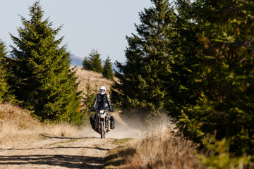 Naklejka premium Motorbiker travelling in autumn mountains
