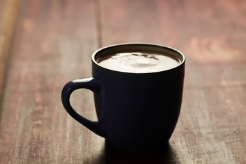 cup of hot chocolate with cinnamon on wooden background