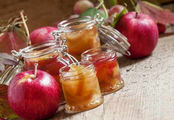 Homemade apple jam in banks in the autumn background with ripe a