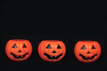 Three plastic pumpkins in a row