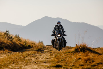 Motorbiker travelling in autumn mountains