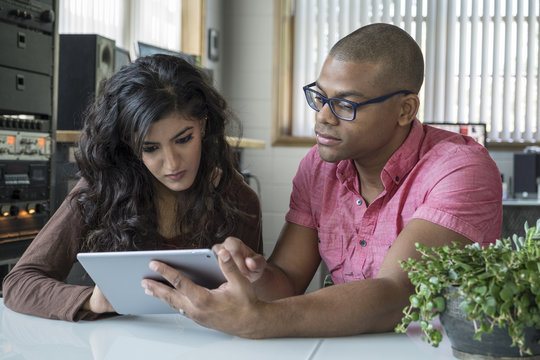 Diverse Professional Team Working Together On An Ipad/tablet In An Office