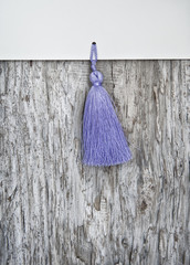 Wooden background with paper and tassel fringe