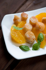 Fried scallops with orange fillet and basil, selective focus