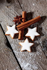 Drei Zimtsterne mit Gewürze auf Holzuntergrund