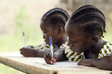 African Children at School Doing Homework. African ethnicity students writing their essay in an...