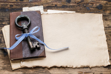 Vintage iron key, old book and secret letters
