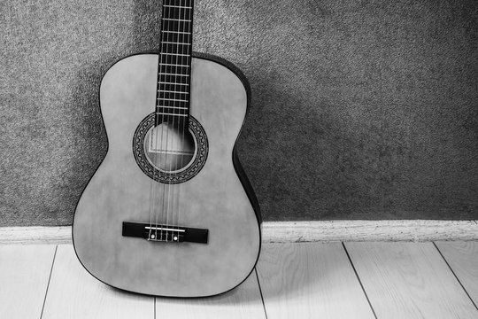 string guitar on the floor near the wall