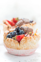 Tartellette di pasta sfoglia riempite di crema e frutta fresca sul tavolo