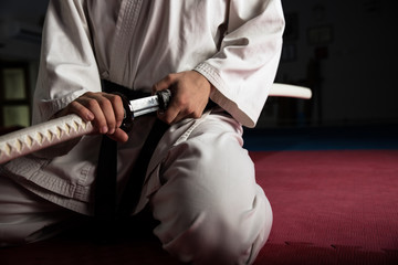 Gros plan sur un jeune combattant d& 39 arts martiaux avec emplacement de katana en position seiza