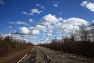Fototapeta na wymiar Autumn road and sky with clouds
