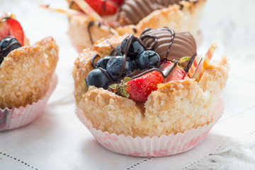 Tartellette di pasta sfoglia riempite di crema e frutta fresca sul tavolo