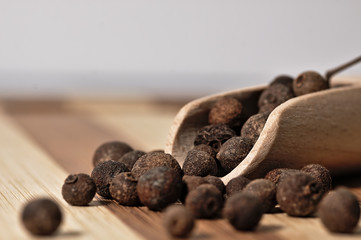 Grains allspice on a wooden board.