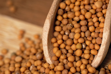 Mustard seed on a wooden, two colored board.