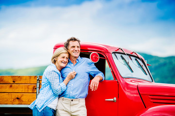 Senior couple with red car