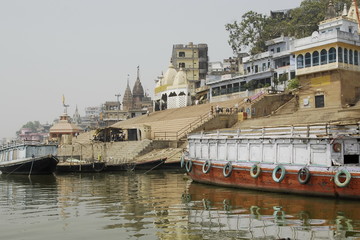 Traditional ghat in Varanasi with passenger boats.