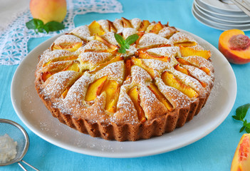Delicate cake with peaches, dusted with icing sugar