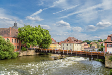 Fototapeta na wymiar Bamberg, Germany. Scenic view of bridges and old buildings on the banks of the Regnitz river.Historic city center of Bamberg is a listed UNESCO world heritage site