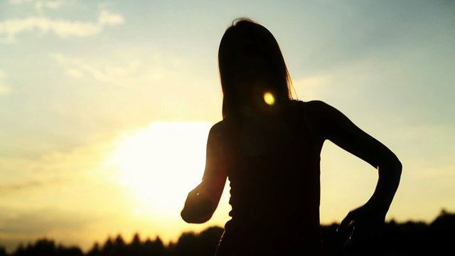 Silhouette of the woman dancing during beautiful sunset. Natural
