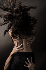 Back of woman with group of male hands on her body