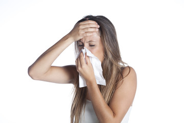 Obraz premium sick young woman blowing her nose isolated on white background
