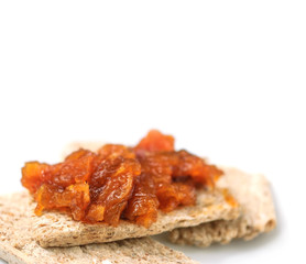 Canapes with homemade onion chutney with ginger and red pepper on a white background. Selective focus on a chutney.