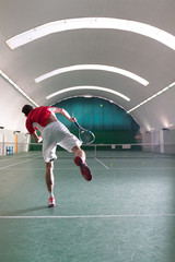 Young tennis player kicking the bal