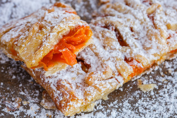 Sweet puff with pumpkin, sprinkled with powdered sugar.selective focus