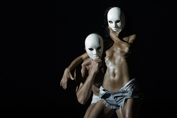 Young naked couple in masks