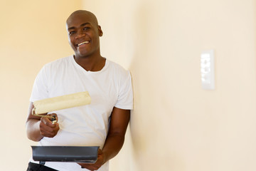 african american man painting wall at home