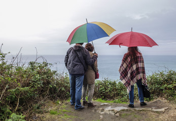 Familia con paraguas frente al mar