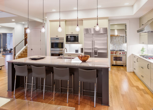 Kitchen Interior in New Luxury Home with Island, Stainless Steel Appliances, Pendant Lights, and Cabinetry