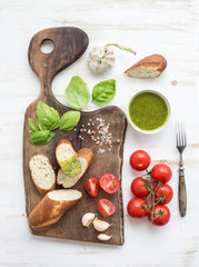 Pesto sauce, bread, cherry-tomatoes, fresh basil and garlic on
