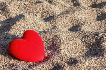 Red heart on the beach with small pebbles  background.