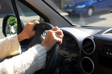Hände einer Seniorin am Steuer ihres Autos - obrazy, fototapety, plakaty