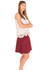 Pretty girl in a vest and skirt behind white wall