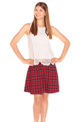 Pretty girl in a vest and skirt behind white wall