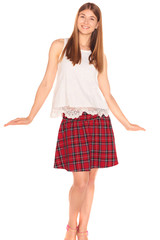 Pretty girl in a vest and skirt behind white wall