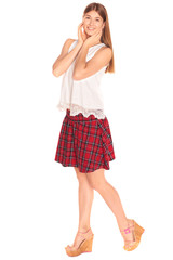 Pretty girl in a vest and skirt behind white wall