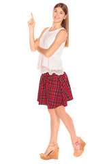 Pretty girl in a vest and skirt behind white wall