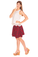 Pretty girl in a vest and skirt behind white wall